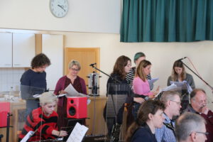 6 Sänger*innen & 1 Keyboarderin beim Musizieren